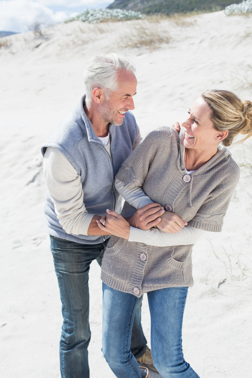 Attractive couple messing about on the beach
